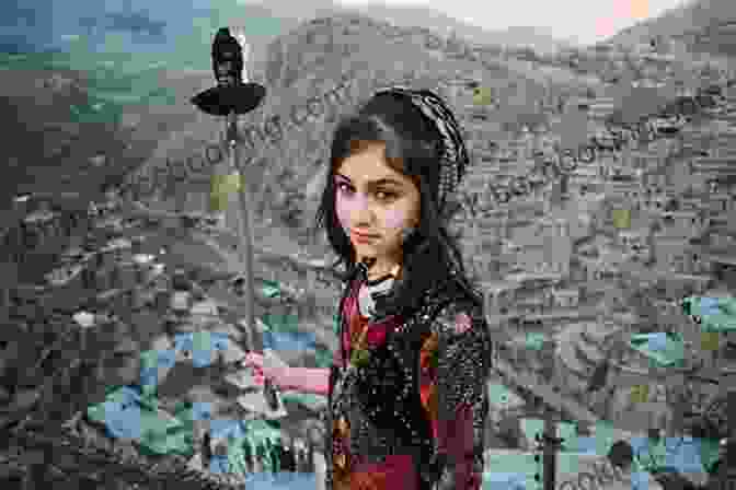A Young Kurdish Girl Sits On A Hillside, Her Eyes Gazing Intently Towards The Camera. The Mountains And Valleys Of Kurdistan Stretch Out Behind Her, Bathed In Hues Of Gold And Green. Bearing Witness: A Journey To Kurdistan
